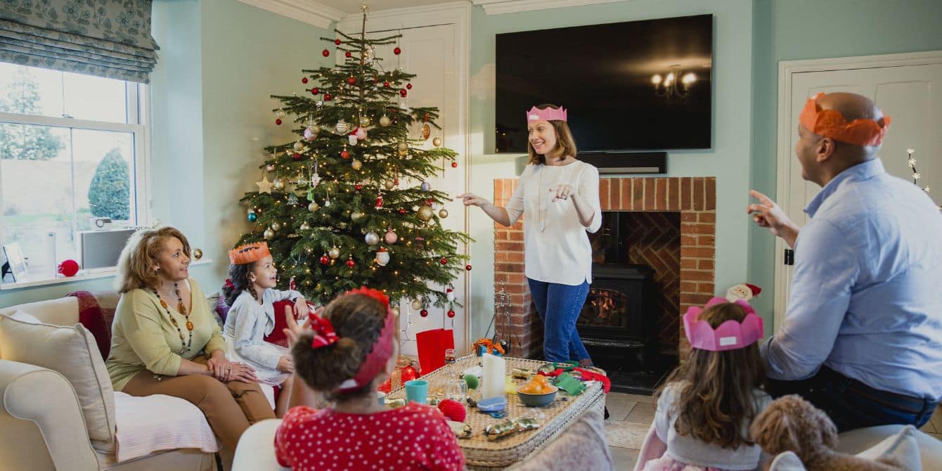 family playing games by christmas tree-christmas games for kids