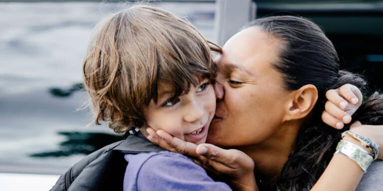 mom with sleepover anxiety dropping kid off and giving a kiss