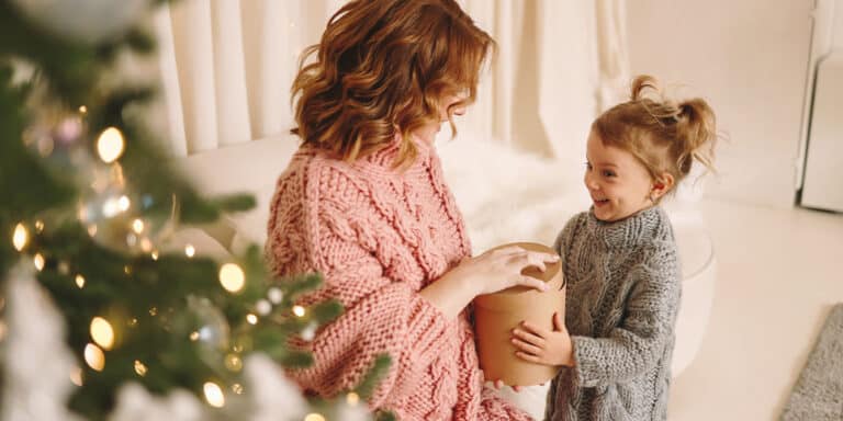 mom giving a gift to her daughter practicing holiday tips