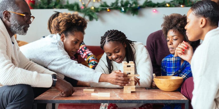 family on christmas playing jenga together showing christmas magic