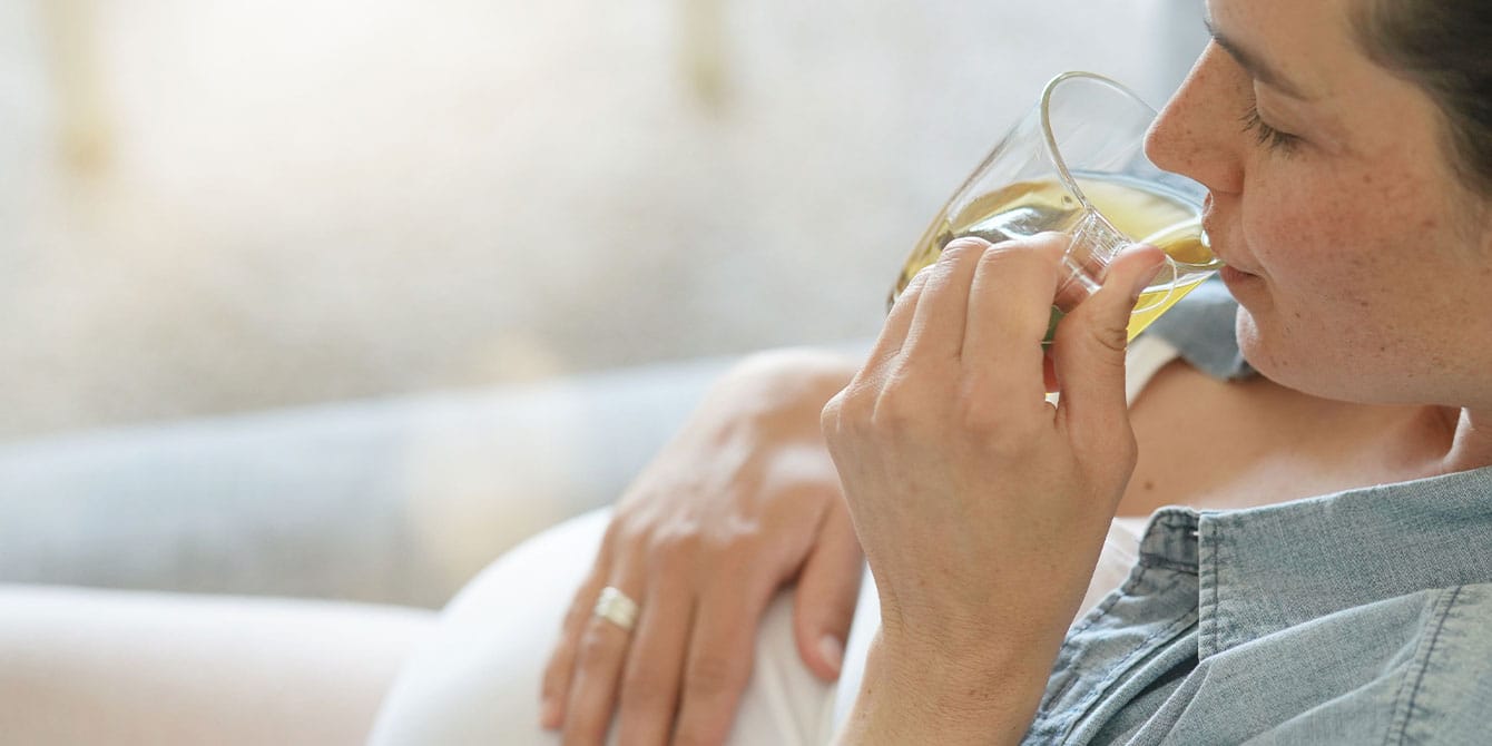 Pregnant woman drinking hot tea - considering the safety of antidepressants during pregnancy