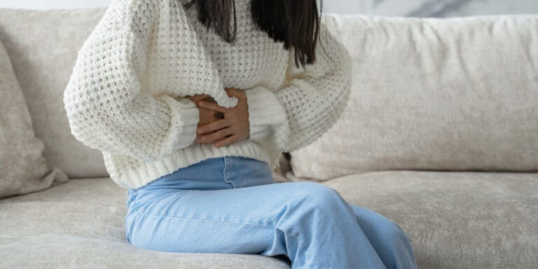 woman holding her stomach - fibroids and phthalates