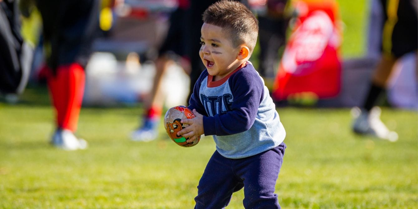 little boy holding football on the field-damar hamlin injury