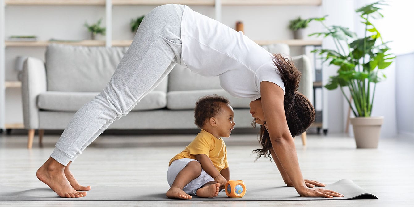 mom finding time to exercise practicing yoga with her baby son