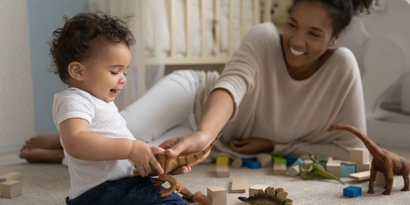 mom and baby playing with a dinosaur - activities for 7-month-old