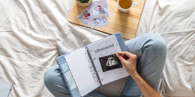 overhead shot of woman writing in a baby book