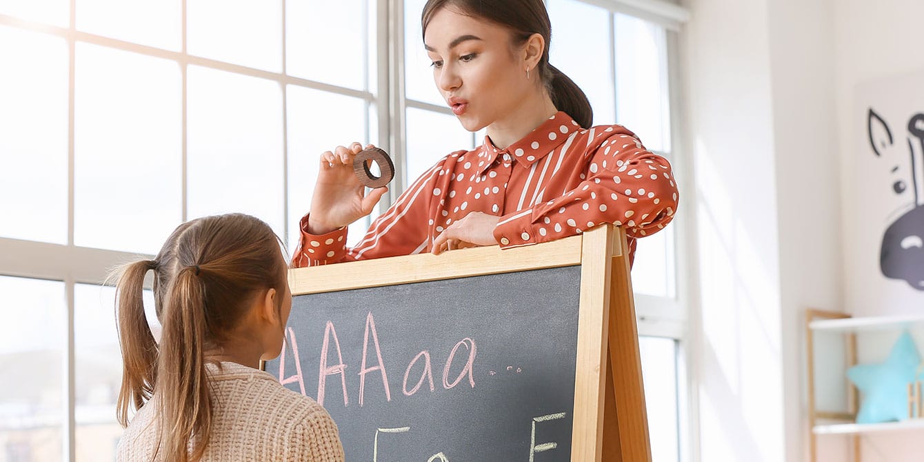 speech therapist working with young girl - dyslexia diagnosis