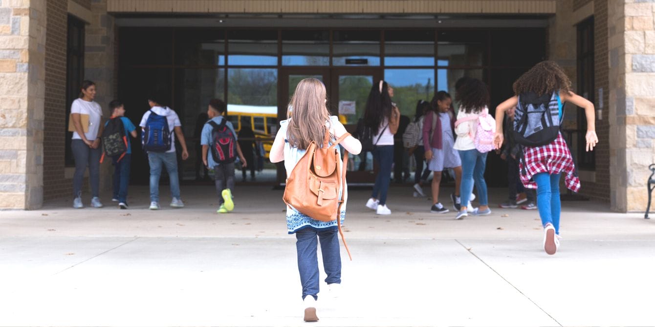 Girls running into elementary school