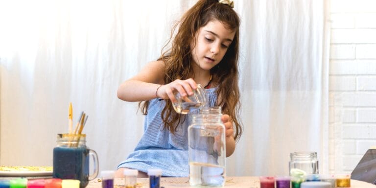 little girl making homemade instruments to make music