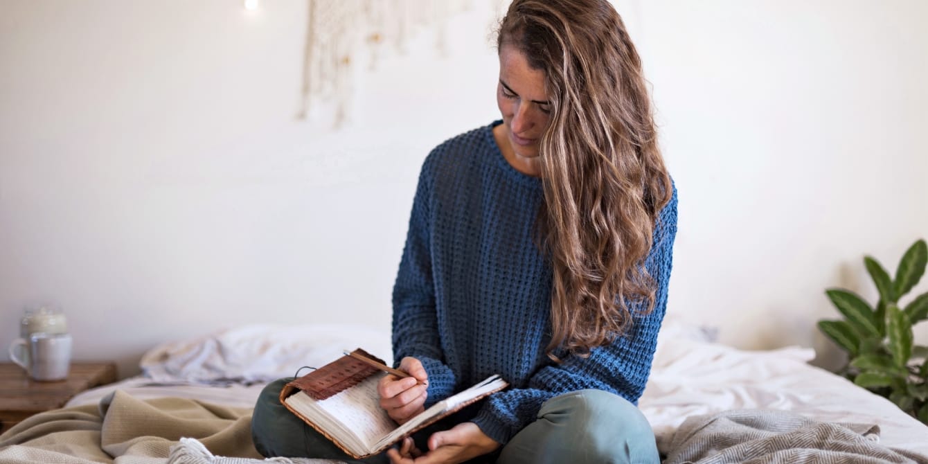 woman writing in a journal- self-care looks different for everyone