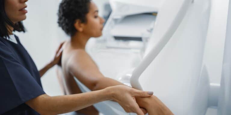 female doctor helping patient with mammogram procedure - mammograms at 40