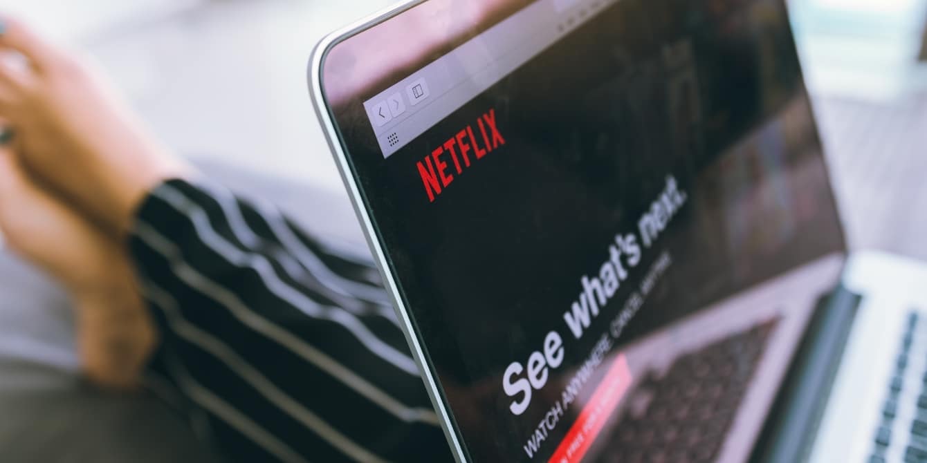 watching netlfix on a laptop- netflix password sharing rules