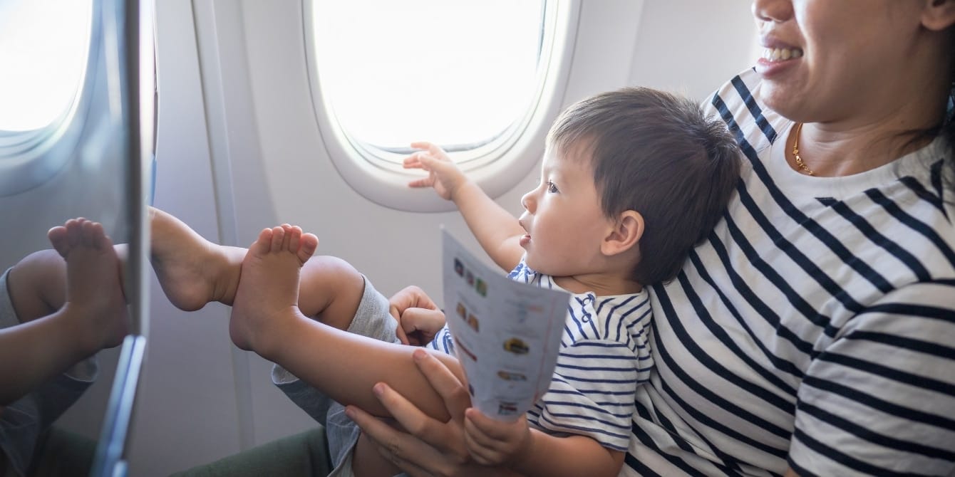 toddler sitting on mom's lap on plane- how to get over jet lag