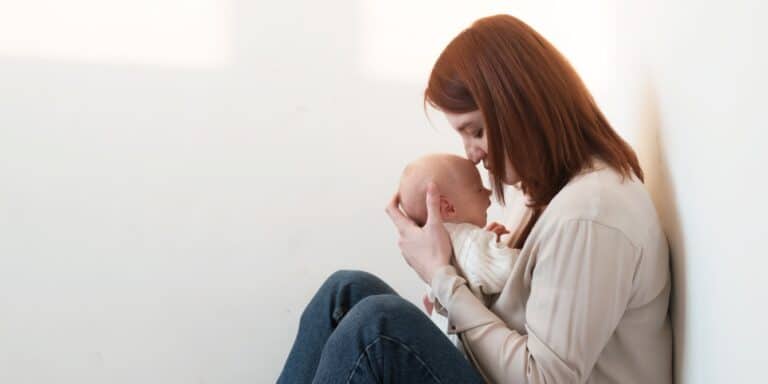 mom kissing baby's head contemplating the worst part of parenting