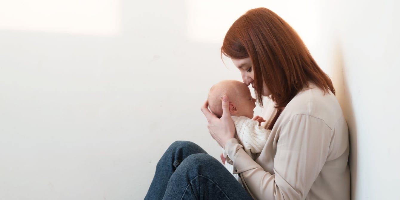 mom kissing baby's head contemplating the worst part of parenting