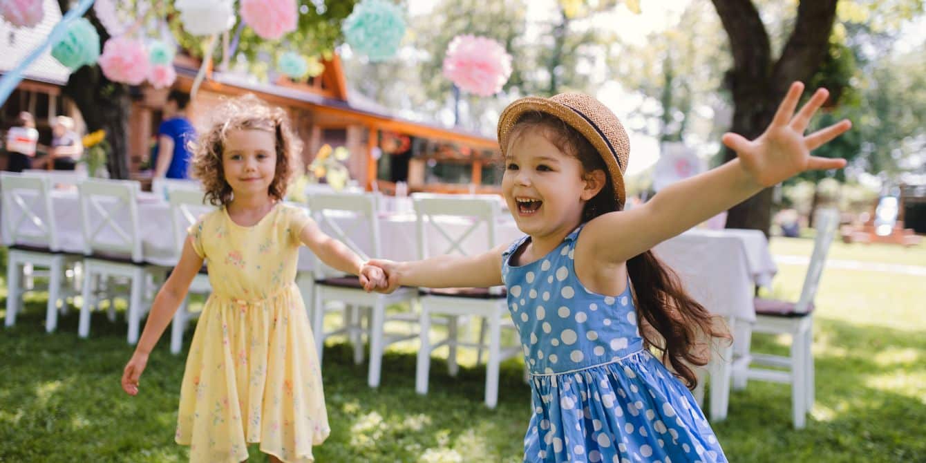 Small girls running outdoors in garden in summer