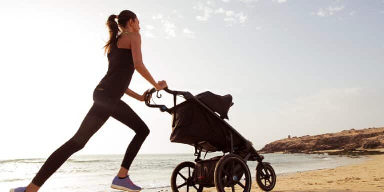 woman jogging on the beach with stroller