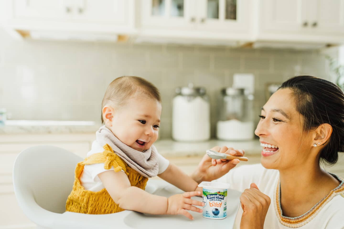 mom feeding yogurt to baby - yogurt first food