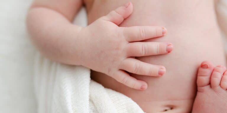 baby with hand on his belly - evivo b. infantis probiotic