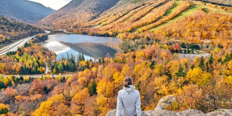 woman amongst fall foliage- best places to see fall foliage