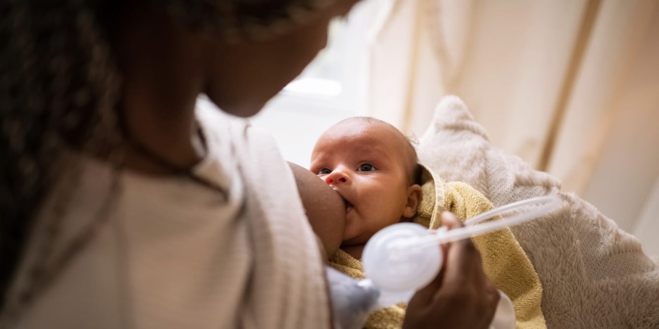 Black woman breastfeeding and pumping simultaneously - power pumping