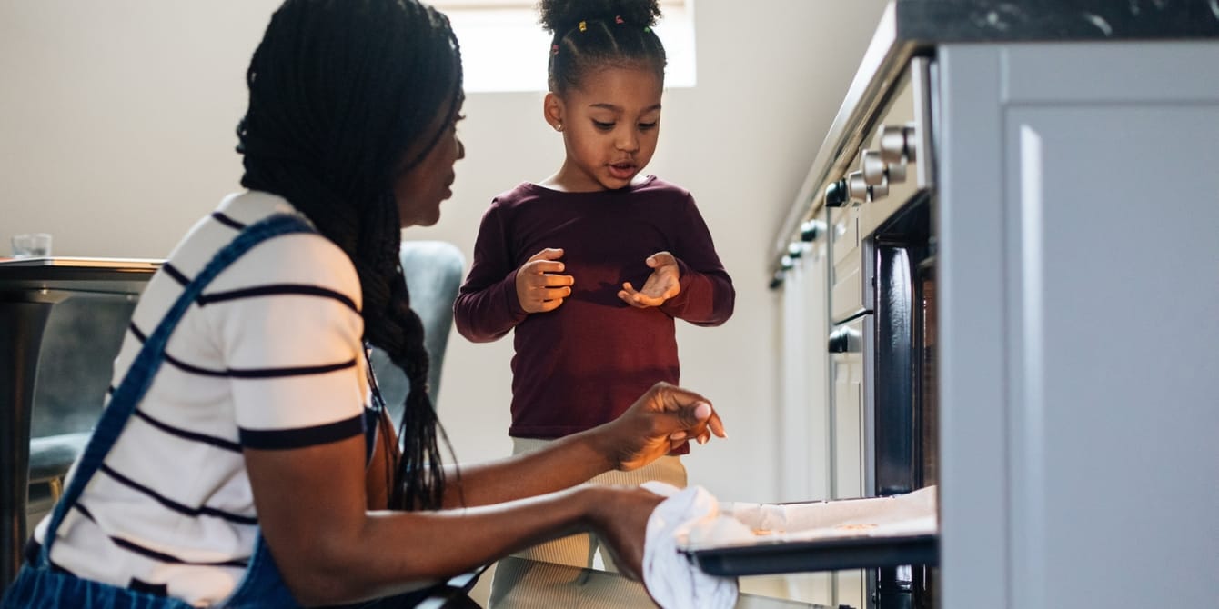 mom and daughter taking baking sheet from oven canned pumpkin recipes