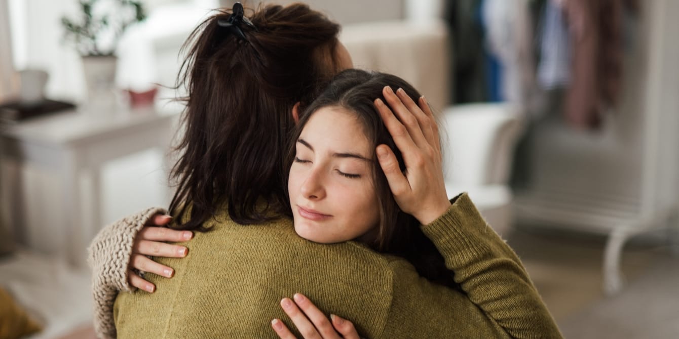 mom hugging her teen daughter - teenager pulling away