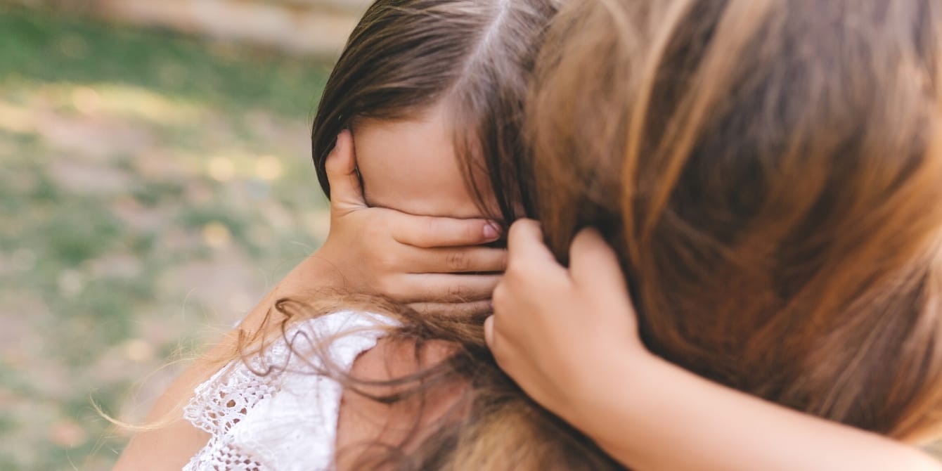 little girl covering her eyes and hugging mom- protecting children's innocence