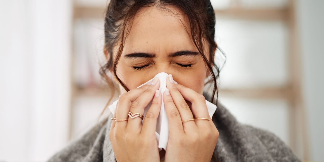 woman blowing her nose in tissue - long cold