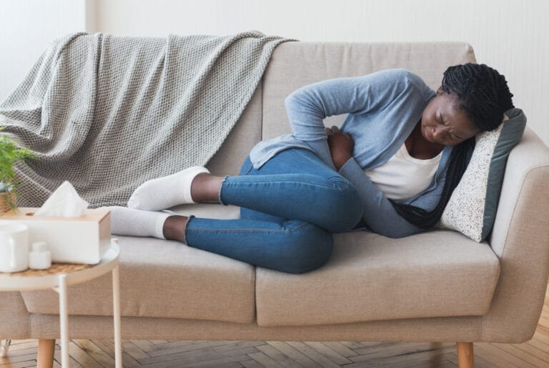 woman lying on the couch in pain