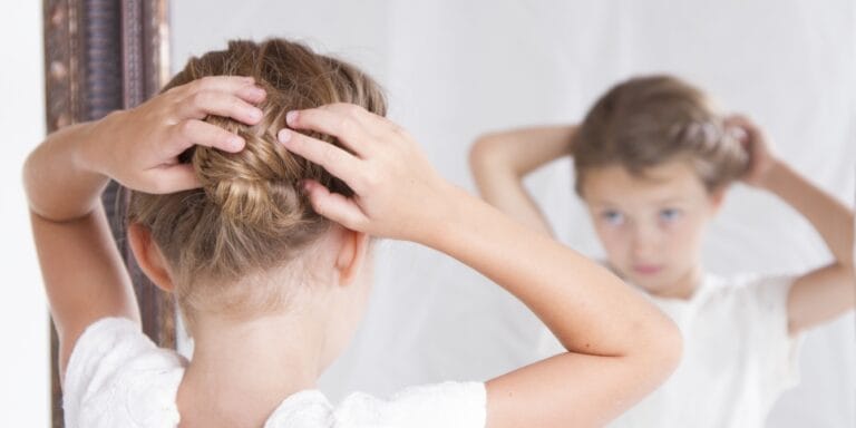 young girl doing her hair in the mirror - body neutrality