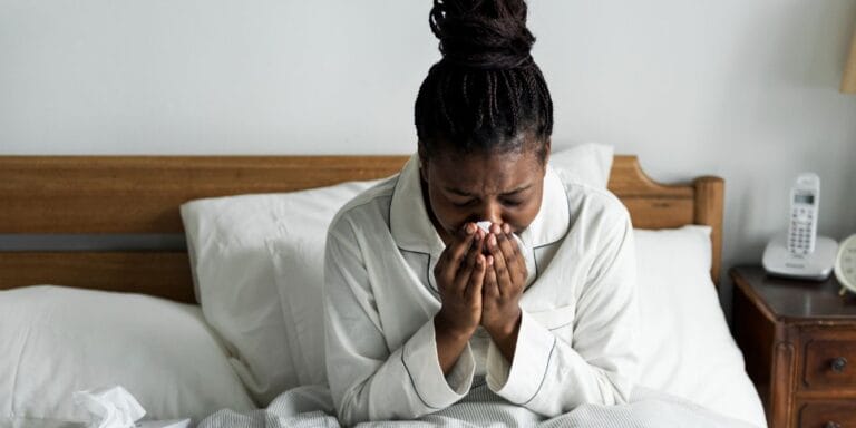 woman sick in bed- flu and exhaustion season