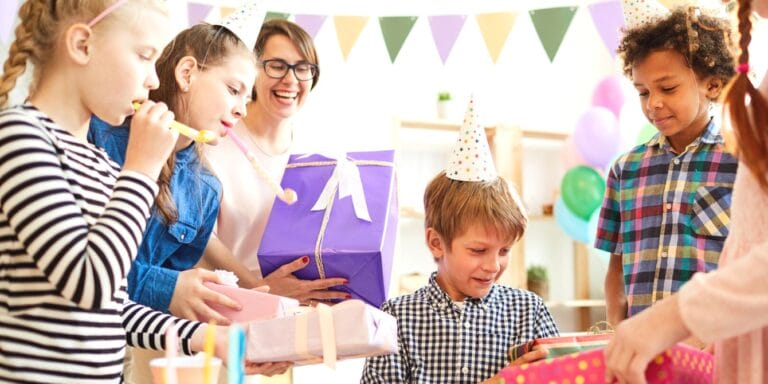 Child opening presents at birthday party