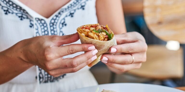 close up woman holding a burrito dietary carbon footprint