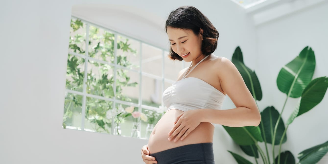 happy pregnant woman touching her belly - pregnancy glow