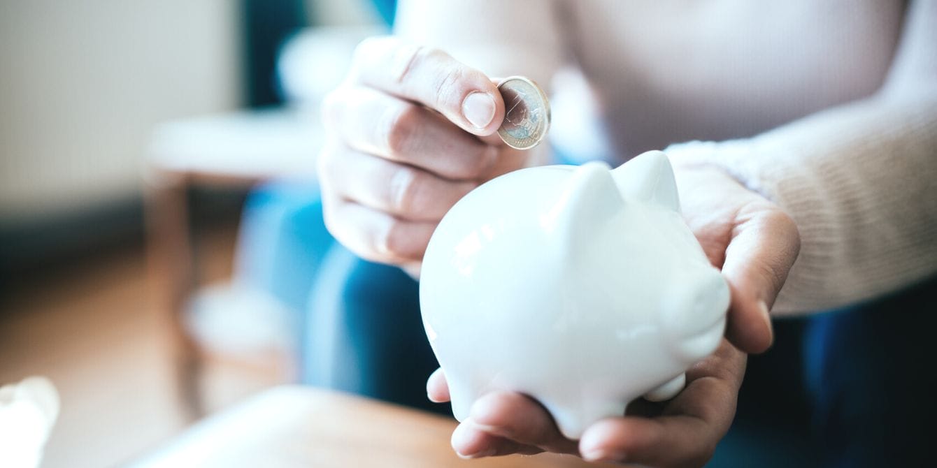 Woman putting coins in piggy bank