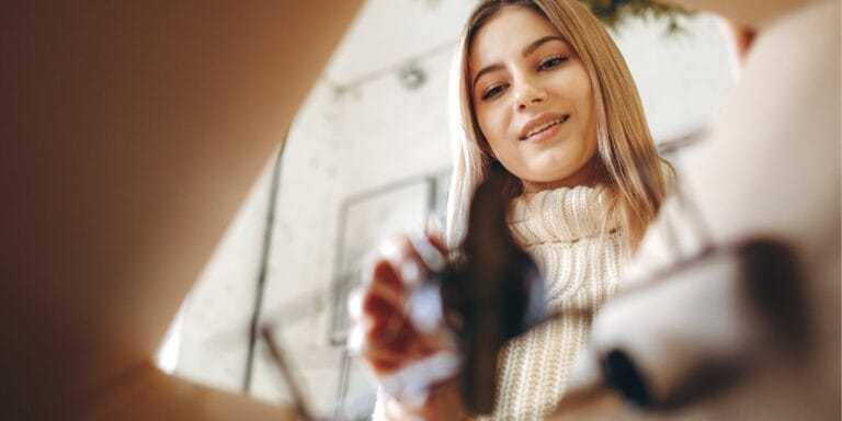 woman taking gifts out of a box- buy nothing gift