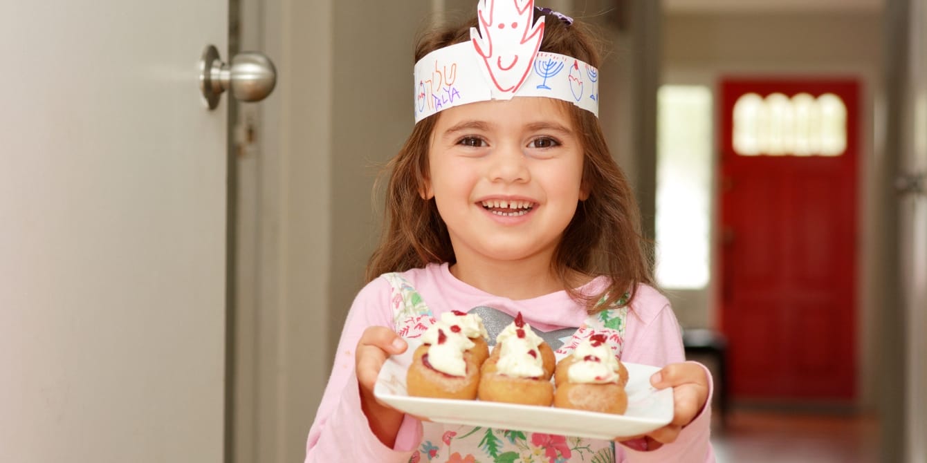 little girl holding plate of treats - kid-friendly hanukkah recipes