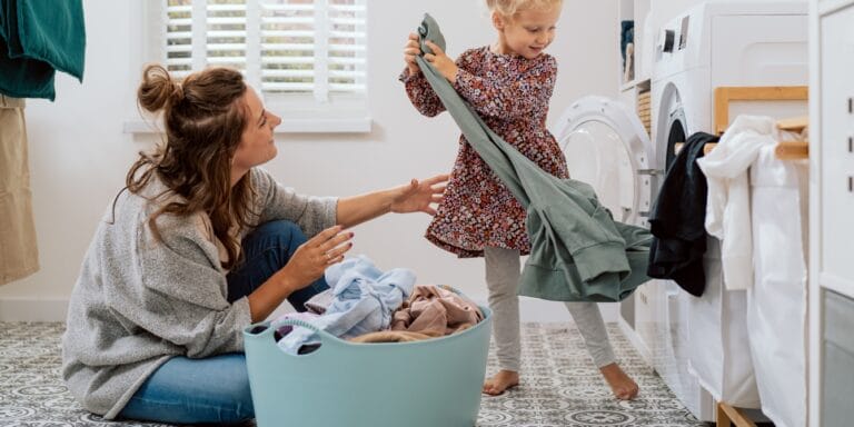 mom and daughter doing laundry managing a home is work