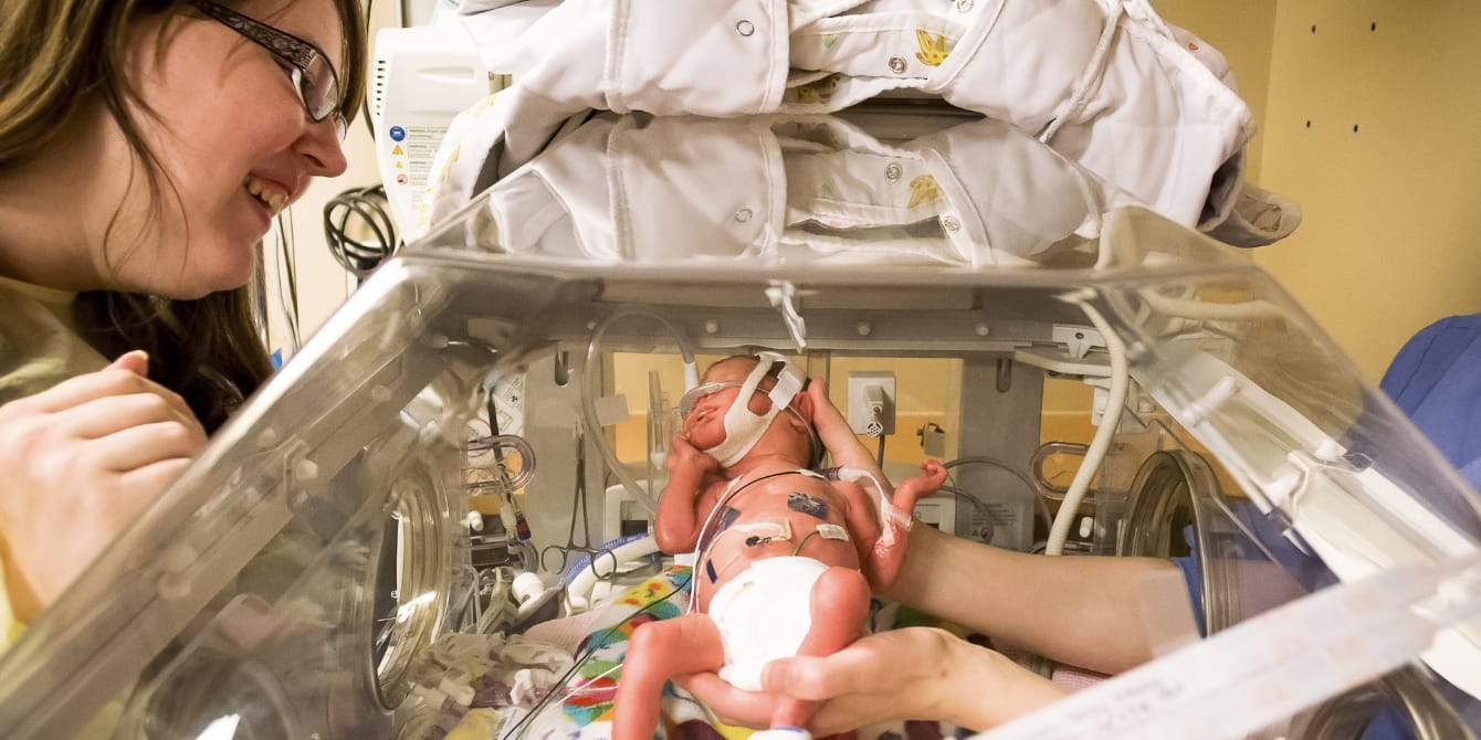 mom looking at her baby in nicu mama friend