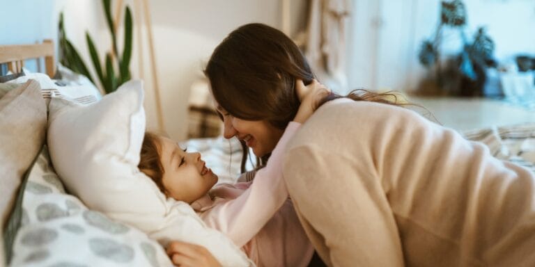 mother putting her daughter to bed