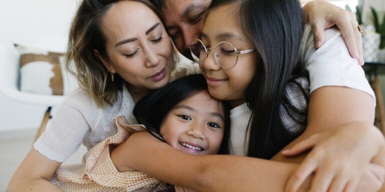 family hugging at home parenting values