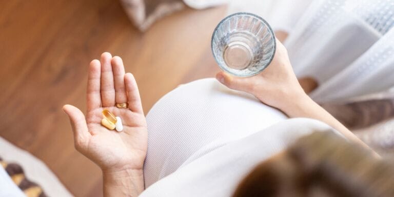 pregnant woman holding prenatal vitamins