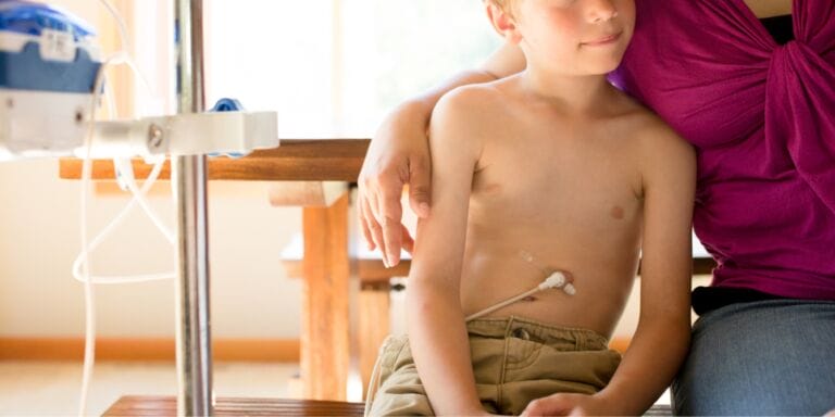 Boy being fed through g tube sitting with mother