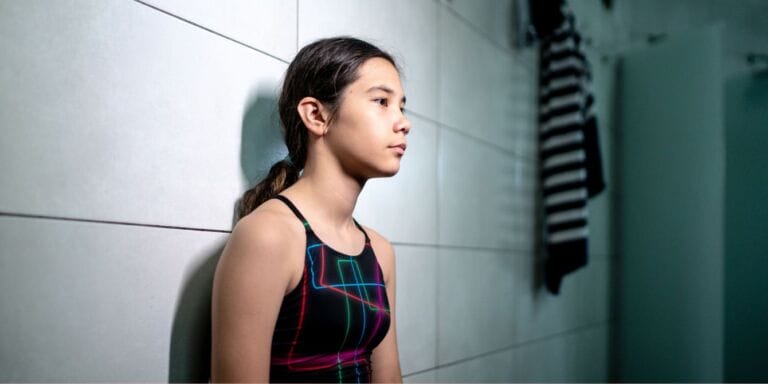 Girl sitting alone in locker room