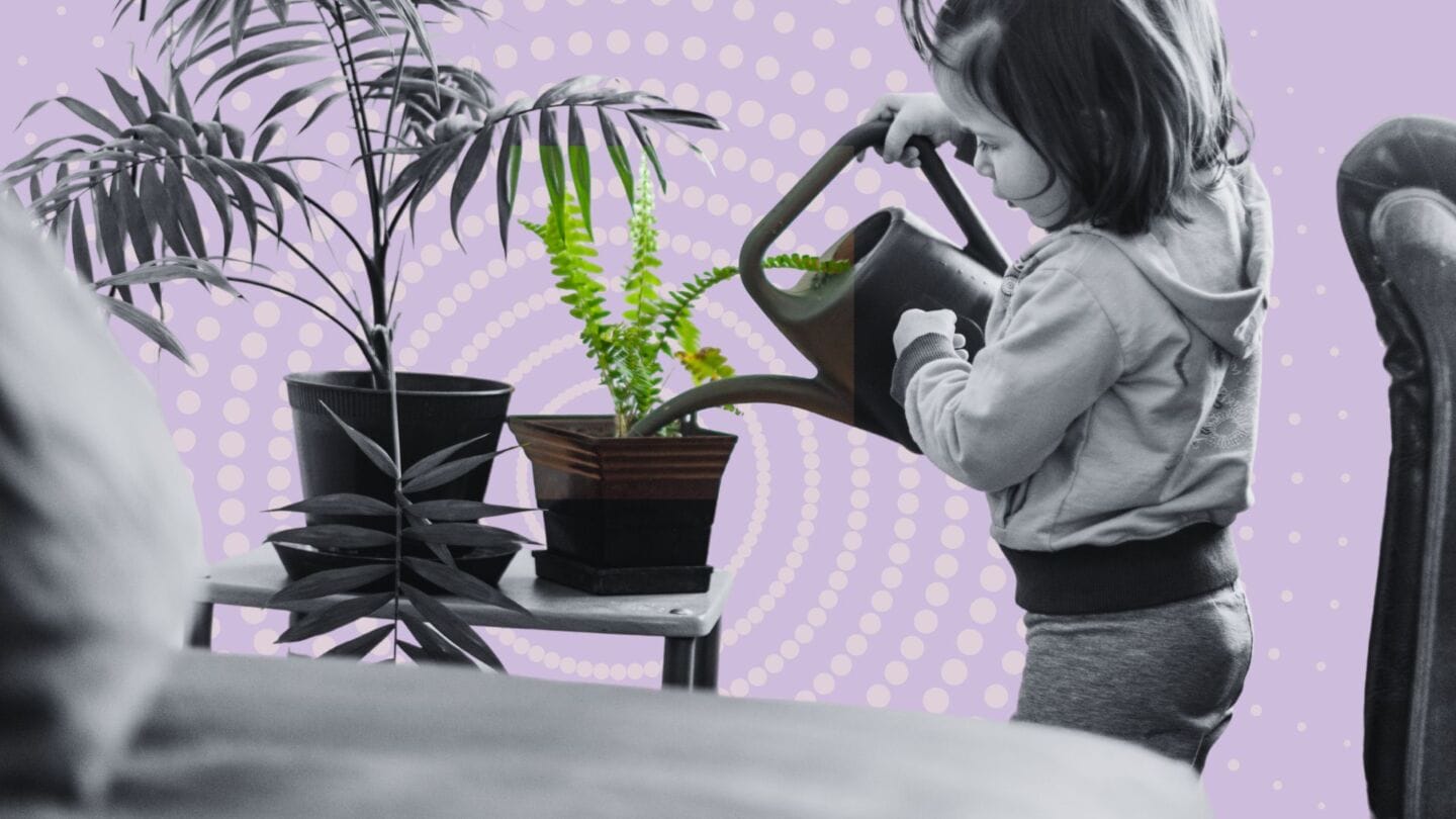 child holding a watering can watering plants