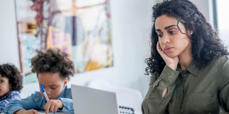 Stressed mom on computer at home with kids