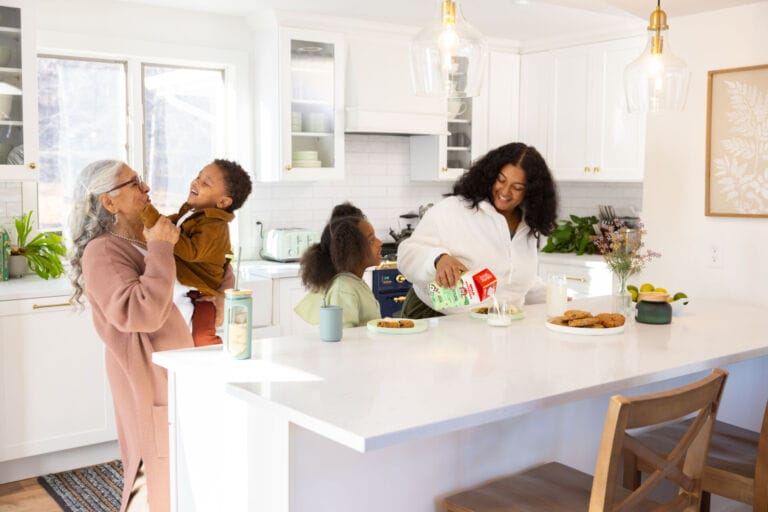 Family gathered in kitchen - Organic Valley Family First Milk