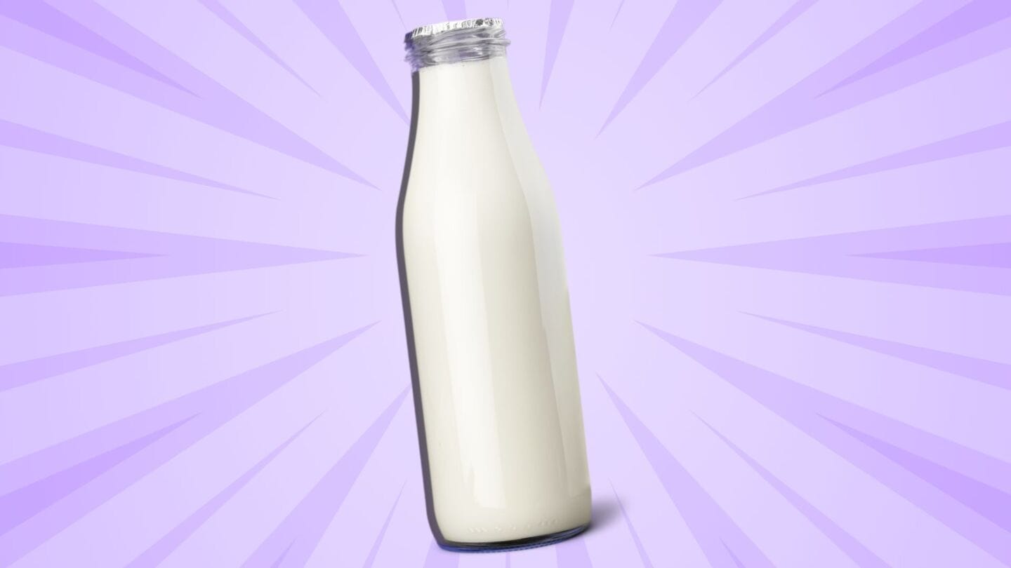 glass bottle of milk on purple background