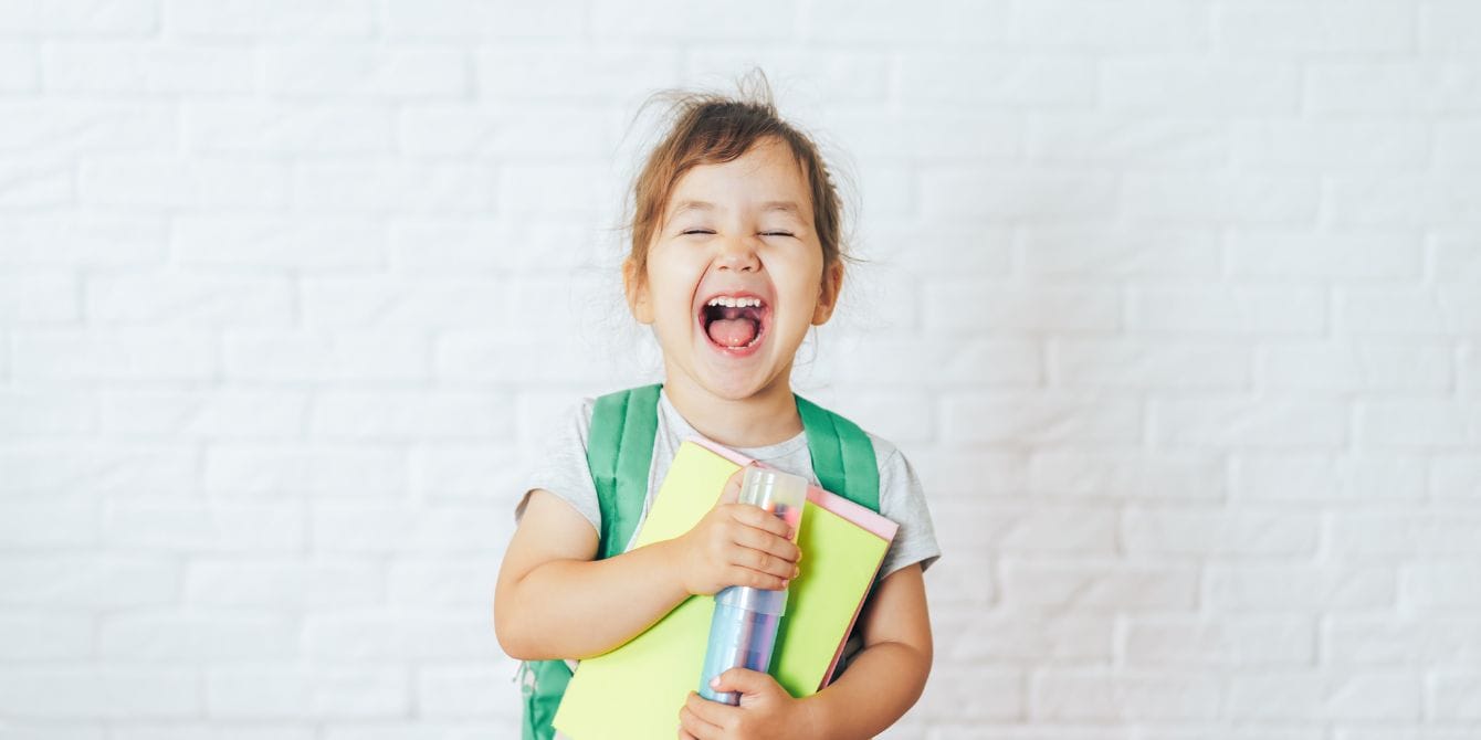 Child smiling wearing backpack - skills for a successful school year